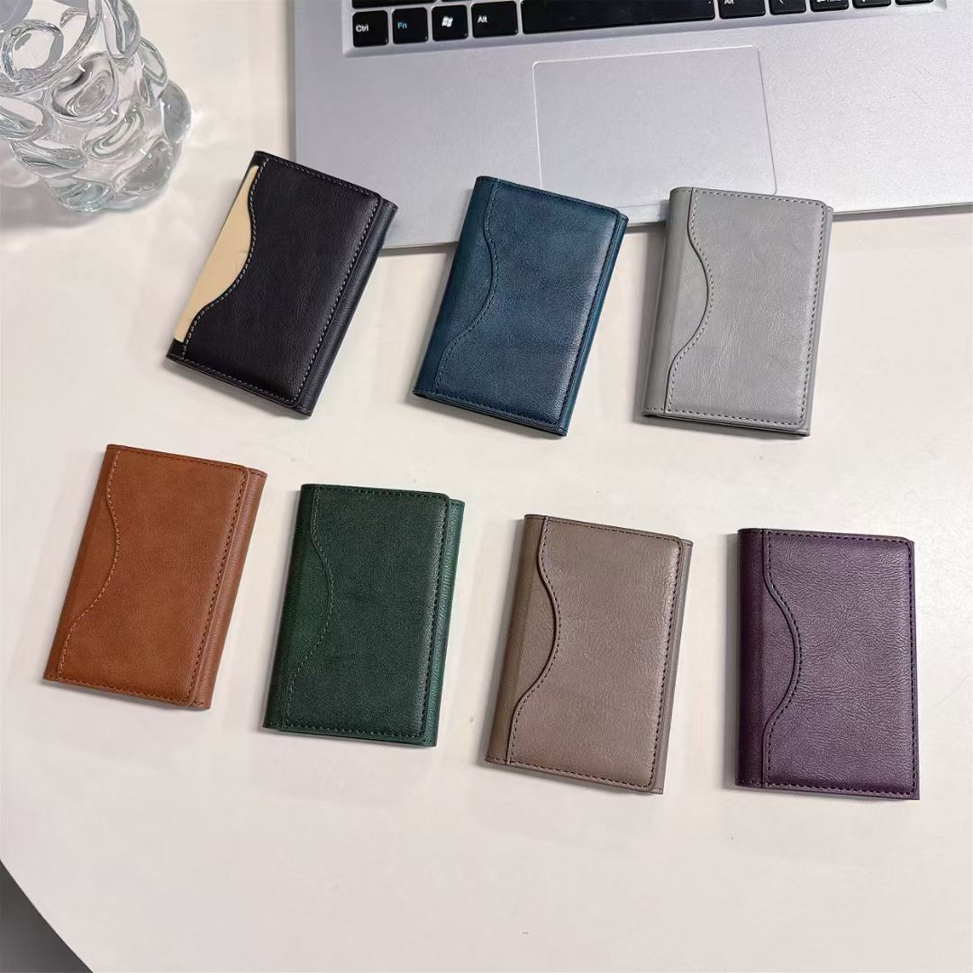 Set of seven small Hand Leather Magnetic iPhone Wallets  in various colors on a light surface.