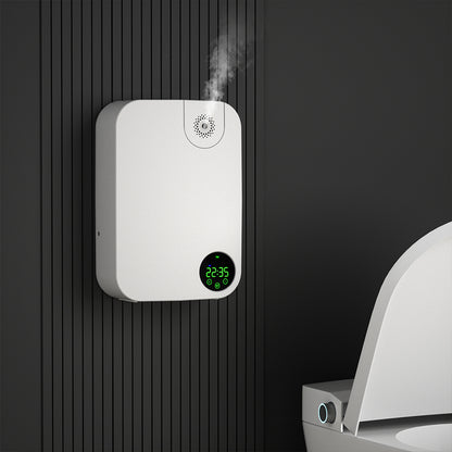 White electronic  Odor Removal Diffuser device with digital display attached to a black wall next to a toilet.