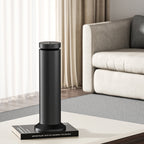 Black humidifier emitting steam on a marble desk with a computer monitor in the background.