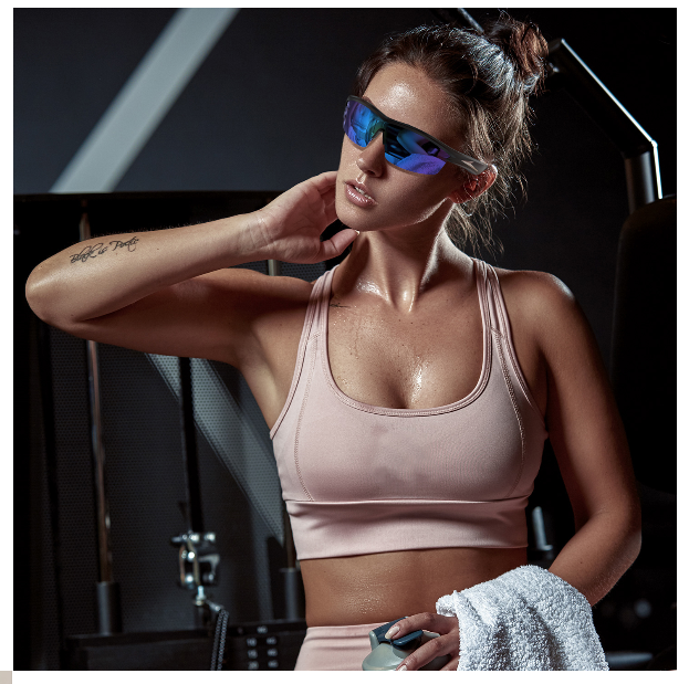 Woman in athletic wear with a Blue Smart Bluetooth Sport glasses  in a gym setting