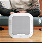 White White Noise Sound device on a wooden surface with a blurred person in the background