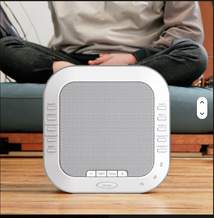 White White Noise Sound device on a wooden surface with a blurred person in the background